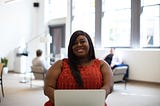 Smiling Black woman at a computer