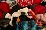 A close-up of a bin filled with loose, colorful socks.