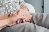holding the hand of an elderly woman