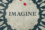 An iconic picture of New York City’s Central Park’s tribute to John Lennon: the “Imagine” mosaic seen from above with two roses lying on the tiles.