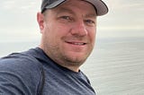 This is a picture of Scott Cate in a hat overlooking the oceans of Peru.