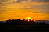 Sun setting over a mountain range in the distance