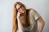 Photo of a white, blonde, long-haired woman wearing glasses.