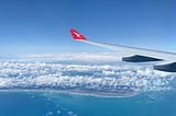The view heading into Auckland airport. Clear blue water and white clouds suspended above the landscape.