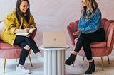 Two women in a meeting looking at a laptop