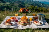 A picnic set out woth delicious foid amid glorious scenery of the mountains.
