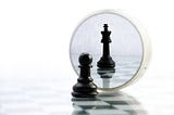 Pawn looking through the magnifying glass and seeing itself as King piece. image from Istock photos