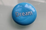A blue stone with the word dream etched onto weight