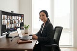 Executive leading a virtual meeting on a laptop with a headset in a home office