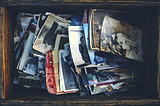 A top view of a wooden box full of vintage photographs
