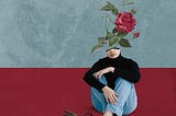 Digital collage art. Woman sitting on the floor, scissors beside her, a rose growing from her head.
