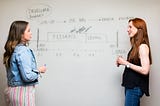 two developers in front of a whiteboard showing an API launch plan