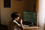 Child sitting at a desk, coding