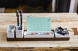 A very tidy desk organizer holding pens, coins, and keys. The image gives a clear impression that the owner of these objects is highly organized.