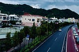 A street in Okinawa Japan. The street is meticulous and you can see urban decay in the background.