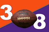 Denver Broncos orange divided by Minnesota Vikings purple with a football in front. In orange background portion, the number 3. In purple background portion, the number 8. These numbers are associated with the respective starting quarterbacks of both teams.