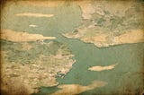 Abstract, vintage-style illustration of The Strait of Gibralatar coastline and open sea, rendered in muted greens and sandy yellows, with layered watercolor textures and a weathered paper surface suggesting an old map or faded landscape.