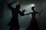 A dark, gloomy picture of a woman in a red dress dancing with the devil.