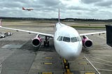 A Wizz Air A321 plane sits at the departure gate of an airport.