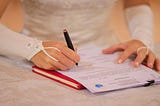 A bride signing her marriage certificate