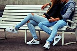 Couple in jeans sitting on the banch