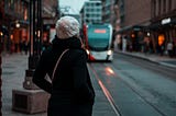 A woman waiting for the bus that is reaching her.