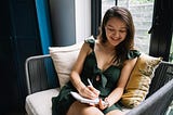 A woman writing in a journal.