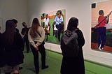 Visitors at The Time Is Always Now: Artists Reframe The Black Figure gather to reflect on paintings being displayed.