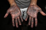 hands palm facing up, covered with engine oil