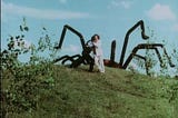 Someone runs away from the Giant Spider, which is just a car with nylon legs on it.