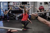 Crossfit coach leading class in overhead squats