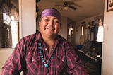 A mature indigenous Navajo man poses for a portrait in the kitchen of his mobile home. Image taken on the Navajo Reservation, Arizona