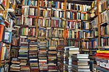 large pile of books and a bookshelf