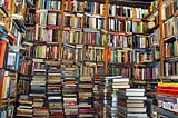 large pile of books and a bookshelf