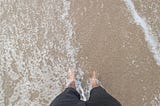 Теплая вода на пляже во Флориде омывает натруженные ноги после долгого путешествия в отпуск