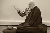 Meditation teacher Shinzen Young sitting next to a meditation bell.