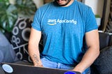 Photograph of a person on a laptop wearing an AWS AppConfig T-shirt