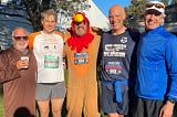 Five runners standing together after finishing a Thanksgiving Turkey Trot (one in turkey costume!)