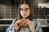 A woman eating burger.