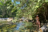 Woman in a bikini at the river surrounded by trees