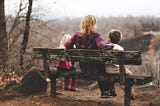 Woman sitting on a bench with her two kids