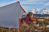 Women looking out from a tent in the Swiss mountains.