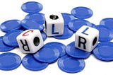 Three dice on a pile of blue coins.