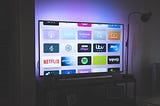 A flat screen TV that shows the icons for most streaming channels including Netflis and Amazon Prime