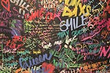 Black wall with colorful graffiti words