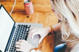 Woman writing on laptop computer