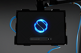 A sleek and futuristic chatbot interface displayed on a mounted screen, featuring a glowing blue AI logo against a minimalist black background.