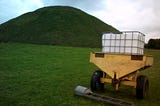 Image of farm trailer in foreground of photograph of Silbury Hill, Wiltshire 2400BC