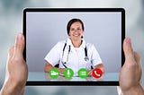 Doctor appears on tablet being held by a patient utilizing telehealth services