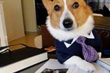 A dog in a suit, sitting at a desk